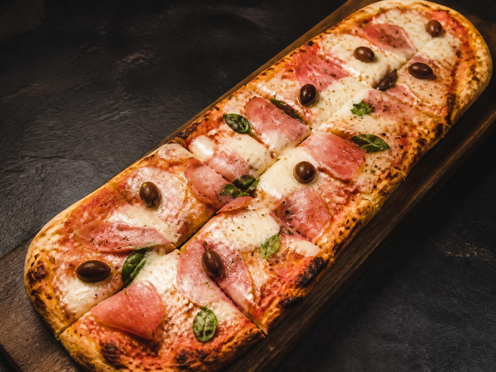 Pizza por metro artesanal de La Caserita Menú Artesanal servida sobre tabla de madera
